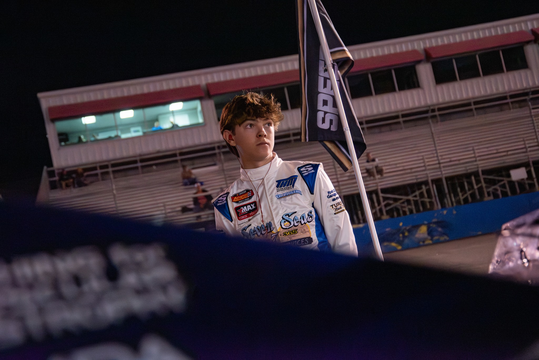 Conner Weddell in his firesuit at the fence at night